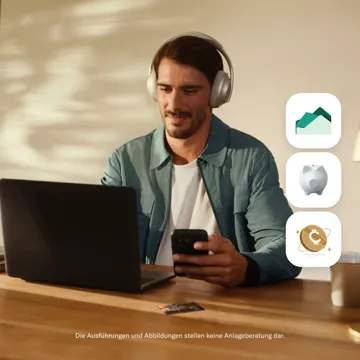 Ein Mann mit Kopfhörern blickt auf sein Smartphone, während er an einem Tisch mit einem geöffneten Laptop, einer Kreditkarte und drei Icons für Immobilien, Sparen und Kryptowährung auf der rechten Seite sitzt.