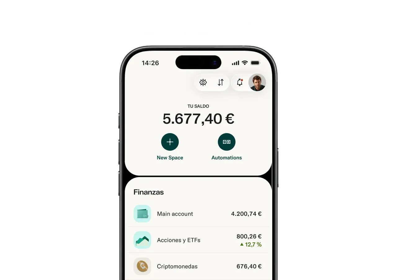 La pantalla de un teléfono inteligente muestra la interfaz de una aplicación bancaria con un saldo total de 5.677,40 € junto con cuentas financieras para cuenta principal, acciones y ETF, y criptomonedas.