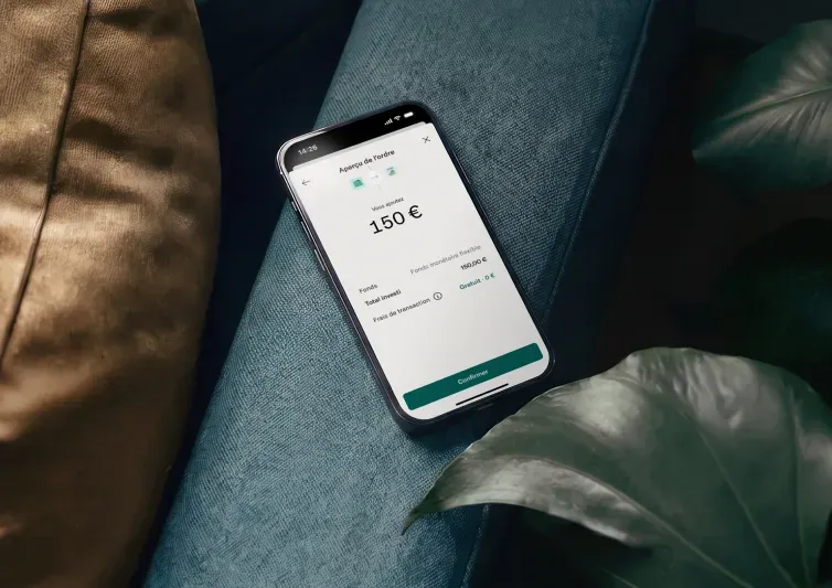 Un smartphone affichant un aperçu de commande d'une application financière pour ajouter 150 € à un fonds en liquidités repose sur une surface bleue à côté d'une feuille de plante.