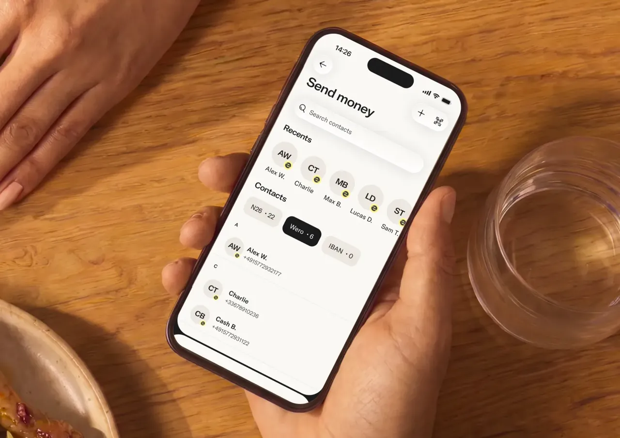Hand holding a phone which displays an interface to send money with different options, Wero is one option among other.