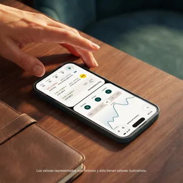 Una mano è appoggiata vicino a uno smartphone su una superficie di legno che mostra la dashboard del portafoglio di investimenti nell'interfaccia dell'app.